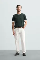 Camiseta azul marino de corte regular, con cuello redondo y mangas cortas. Presenta ribete blanco en cuello y mangas.