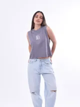 Remera sin mangas, color gris lila, de corte cropped y cuello redondo. Estampado frontal con texto que dice "BORN IN THE 90'S".