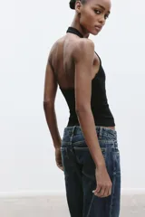 Top color crema con cuello halter y escote redondo. Espalda descubierta.