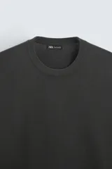 Jersey color topo de corte amplio, tejido en hilatura con mezcla de viscosa. Tiene cuello redondo, manga larga y terminaciones en rib.