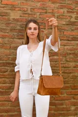 Cartera tipo bandolera color camel con detalles de costura a mano y strap ajustable.