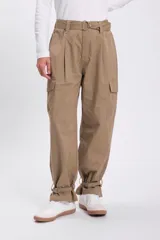 Pantalón color beige, de corte ancho, con bolsillos laterales y cinturón con hebilla metálica.