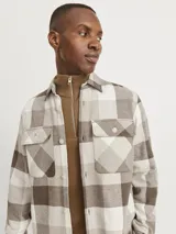 Sobrecamisa a cuadros grandes color marrón, beige y blanco, de manga larga, con cierre de botones y dos bolsillos con botón en el pecho.