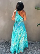 Vestido largo de tela fluida, color azul vibrante con estampado tie-dye en tonos beige/crudo. Diseño halter con tirantes finos ajustables y cintura marcada con lazo.