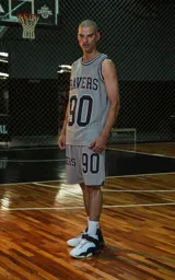 Musculosa deportiva gris con ribetes en cuello y sisas en negro y blanco. Estampado frontal con la palabra "RAVERS" y el número "90" en negro con borde blanco.