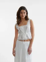 Top corto blanco con cuello cuadrado, sin mangas y detalle de encaje.