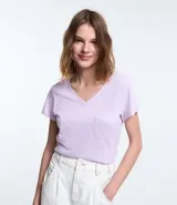 Blusa blanca de algodón con cuello en V, manga corta y bolsillo frontal.