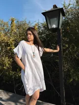 Vestido amarillo de lino con cuello redondo y mangas cortas con dobladillo. Tiene botones de madera en los laterales.