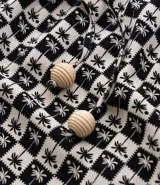 Salida de playa plus size modelo short, confeccionada en viscosa más sostenible, con cintura elástica, bajo con acabado ondulado, superficie de cuadros con estampa de cocoteros y lazo en la cintura.