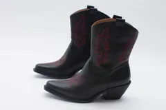 Bota texana de cuero negro con bordados en el lateral y taco bajo.