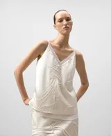 Top de mujer color crudo con escote pico y tirantes finos. Presenta una capa interior de tul y una capa exterior de tejido satinado con un efecto arrugado o drapeado texturizado.