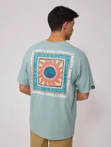 Remera negra de algodón con estampado en la espalda con el logo de Rusty Surf Company en forma de sol con motivos tribales en colores pastel.