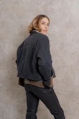 Chaqueta bomber corta color gris oscuro confeccionada en paño de lana. Tiene maxi bolsillos en la delantera con abertura lateral, pespuntes y vistas interiores a contra tono y acceso tradicional con cierre metálico.