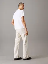 Remera blanca de algodón, con cuello redondo y mangas cortas. Estampado frontal con el logo 'ck' en color celeste difuminado.