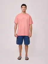 Remera de algodón con efecto lavado, color rosado, de calce oversize. Presenta un estampado grande en la espalda con un sol estilizado, el logo de Rusty y el texto "RUSTY CULTURE AUSTRALIA".