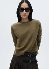 Sweater color verde oliva de tejido de punto fino con cuello redondo y mangas largas con terminaciones en canalé.