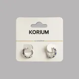 Aros tipo argolla plateados con incrustaciones de circonitas azules y blancas.