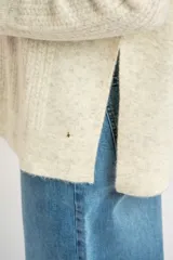 Sweater color beige de tejido texturado, con cuello redondo y mangas largas.