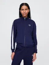 Campera deportiva Gap azul marino con cierre frontal, cuello alto y logo bordado en el pecho. Presenta dos líneas blancas verticales a lo largo de las mangas.
