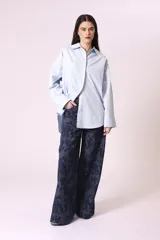 Pantalón de jean de corte ancho con estampado abstracto en tonos azules.