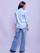 Camisa entallada de manga larga color rosa claro, con cuello clásico y cierre frontal con botones.