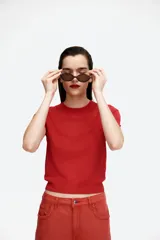 Remera de punto fino color rojo, de corte entallado, con cuello redondo y mangas cortas.