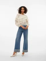 Blusa color crema con volados, cuello redondo y mangas largas con puños abotonados.