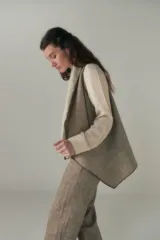 Chaleco marrón con diseño a cuadros, solapas anchas y bolsillos laterales.