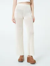 Pantalón de hilo color crudo, tejido de punto calado, con cintura elástica.