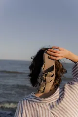 Sandalias tipo mule de cuero color marrón chocolate, con diseño de tiras anchas cruzadas y suela plana.