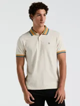 Polo manga corta color crema con cuello y puños a rayas en tonos azul y naranja.