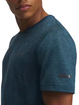 Remera deportiva gris jaspeado de corte clásico, con cuello redondo y mangas cortas. Confeccionada con tejido de punto transpirable y tecnología seamless para mayor comodidad.