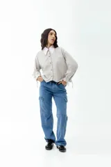 Pantalón cargo de jean celeste con lavado esfumado, tiro bajo, pierna ancha y bolsillos cargo.
