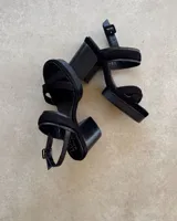 Sandalias de cuero vacuno color negro, con plataforma y taco ancho.