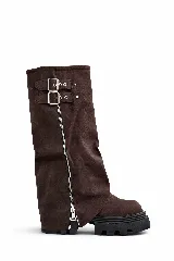 Bota alta de caña ancha color marrón oscuro, con suela track gruesa y negra. Presenta un cierre lateral completo y detalles de hebillas ajustables en la parte superior.