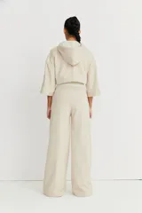 Pantalón de corte amplio color beige, con detalle de alforza central, recortes laterales y cintura elastizada en la espalda. Amplios bolsillos. Marca Zettia.
