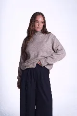 Sweater color crema de tejido de punto con cuello alto y mangas largas.