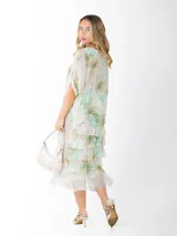 Vestido dos en uno confeccionado en seda italiana, con capa superior de calce amplio y falda con volados que aportan movimiento. Incluye forro en algodón elastizado.