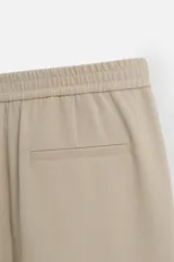 Pantalón negro de corte recto con cintura elástica, bolsillos laterales y un bolsillo trasero de ojal.