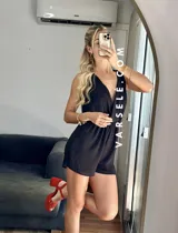 Mono corto negro con escote en V cruzado, sin mangas y con cinturón dorado.