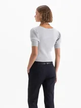 Top corto gris de punto acanalado, con escote redondo, manga corta abullonada y cierre frontal con tres ganchos decorados con piedras.