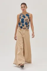 Pantalón jean de pierna ancha color beige, con cintura elastizada y bolsillos traseros cuadrados.