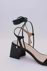 Sandalias rojas de cuero con tiras finas para atar al tobillo y tacón cuadrado.