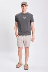 Bermuda casual de lino a rayas verticales color beige con cordón ajustable en la cintura.