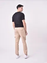Pantalón jogger gris oscuro con cintura elástica ajustable con cordón, bolsillos laterales y bolsillo cargo con solapa en la pierna. Puños elásticos en los tobillos.