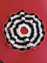 Gomita de pelo tejida al crochet con hilo de algodón a rayas en tonos rosa y violeta, con borde gris.