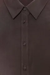 Camisa blanca de cuello solapa y manga larga con pliegues. Bajo asimétrico y cierre frontal con botones.