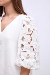 Vestido corto blanco de lino con escote en V y mangas cortas abullonadas con detalles de broderie.