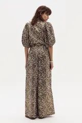 Pantalón culotte de lino con estampado abstracto en tonos marrones y beige. Tiene cintura alta con pinzas, bolsillos laterales y cierre frontal.