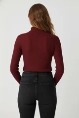 Polera de manga larga color beige claro, de tejido acanalado y cuello alto, de calce ajustado al cuerpo.